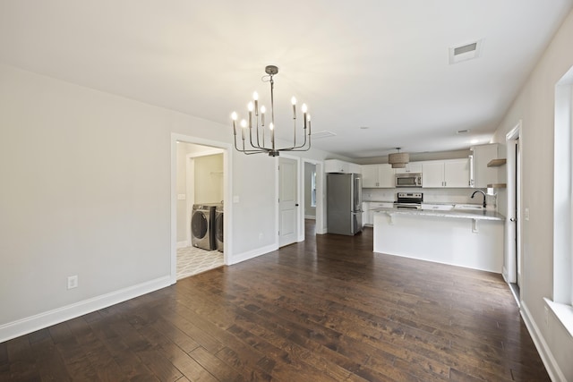 1506 Southwick Dr, Johns Island, SC 29455 - unfurnished living room featuring washer and clothes dryer, a chandelier, a sink, and dark wood-style flooring
