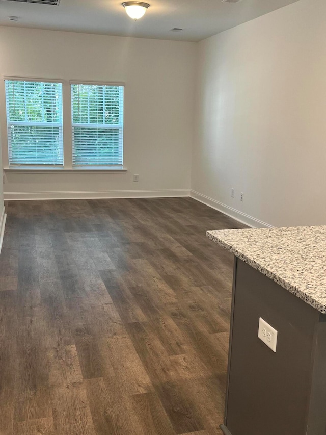 empty room with dark hardwood / wood-style floors and built in desk