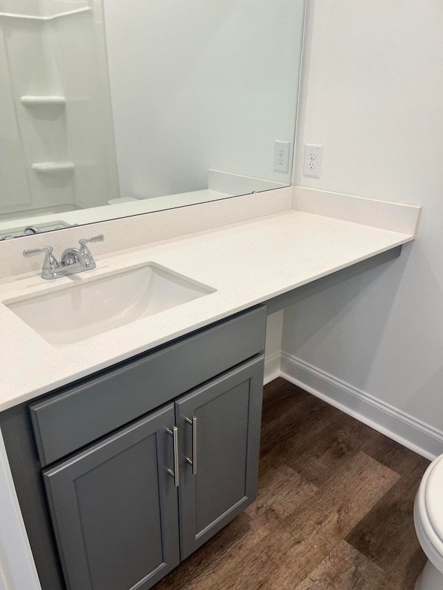 bathroom with hardwood / wood-style flooring, toilet, and vanity