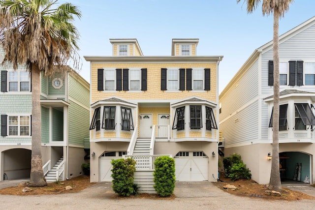 116 W 2nd St, Folly Beach, SC 29439 - view of front of home with stairs, an attached garage, and stucco siding
