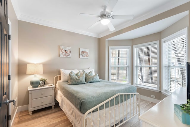 116 W 2nd St, Folly Beach, SC 29439 - bedroom with crown molding, baseboards, multiple windows, light wood-style floors, and ceiling fan