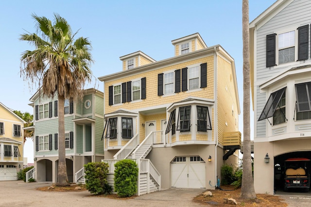 116 W 2nd St, Folly Beach, SC 29439 - view of front of house featuring a garage, stairs, driveway, and stucco siding