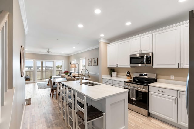 116 W 2nd St, Folly Beach, SC 29439 - kitchen with stainless steel appliances, a sink, crown molding, open floor plan, and an island with sink