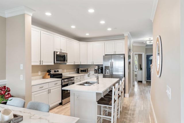 116 W 2nd St, Folly Beach, SC 29439 - kitchen with appliances with stainless steel finishes, a sink, ornamental molding, white cabinetry, and a breakfast bar