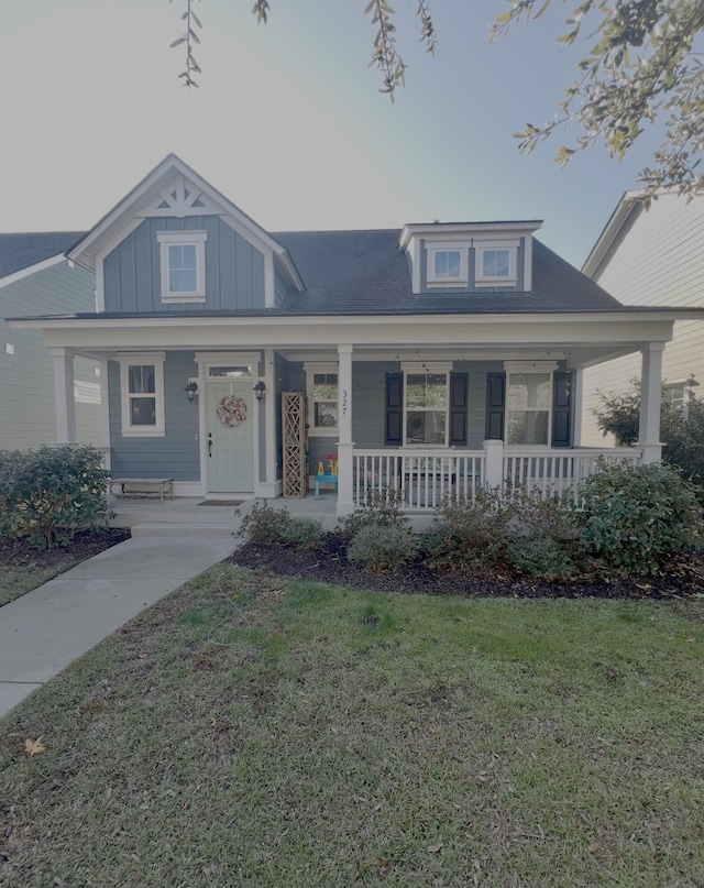 view of front of property featuring covered porch and a front lawn