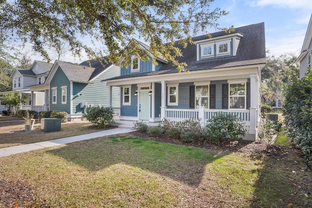 cape cod home with central AC, covered porch, and a front lawn