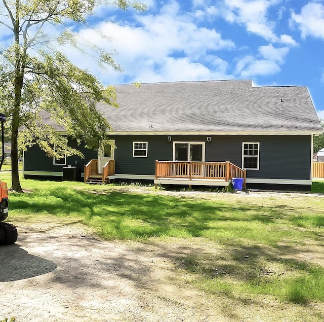 rear view of property featuring a wooden deck and a yard