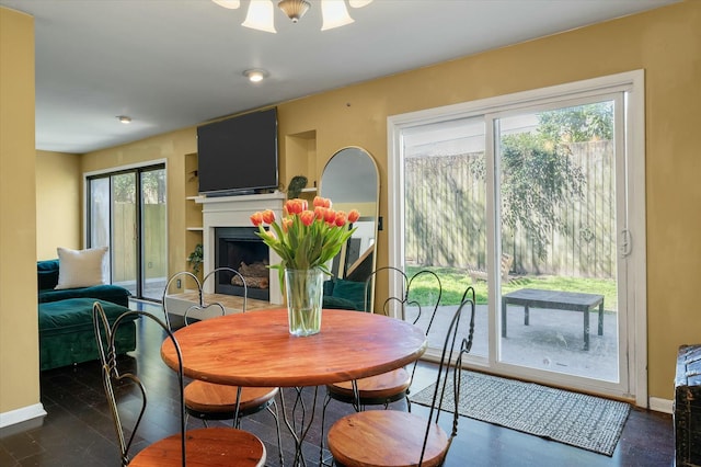 dining space with a fireplace and baseboards