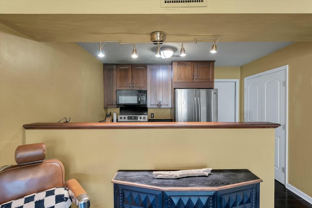 kitchen with visible vents, a kitchen breakfast bar, stainless steel appliances, and baseboards