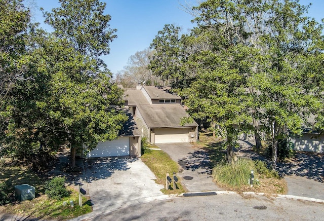 view of front of house with a chimney and driveway