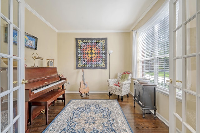 living area with ornamental molding, dark wood-type flooring, and baseboards