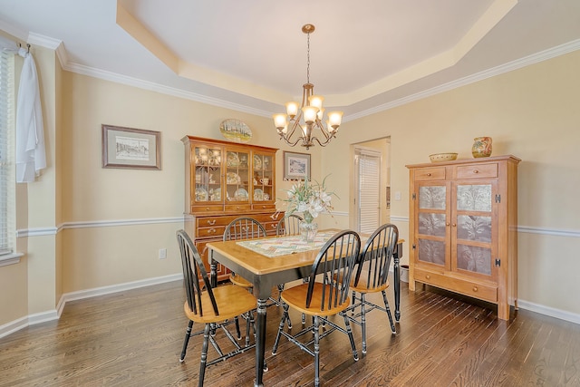 dining space with a chandelier, dark wood-style floors, a raised ceiling, crown molding, and baseboards