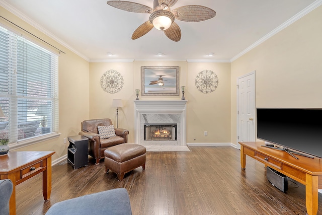 living room with a ceiling fan, baseboards, crown molding, and wood finished floors