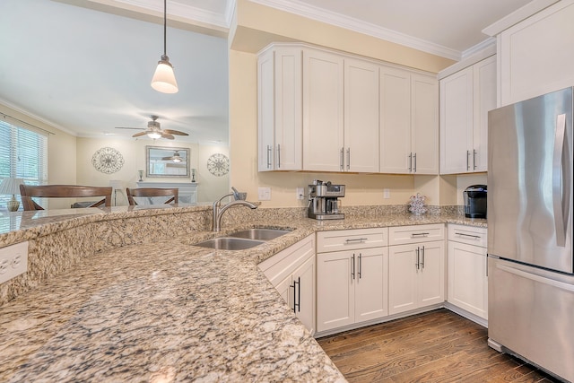 kitchen with freestanding refrigerator, ornamental molding, a sink, dark wood finished floors, and ceiling fan