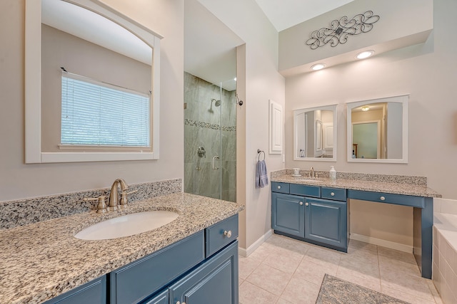 bathroom with a shower stall, two vanities, tile patterned floors, and baseboards