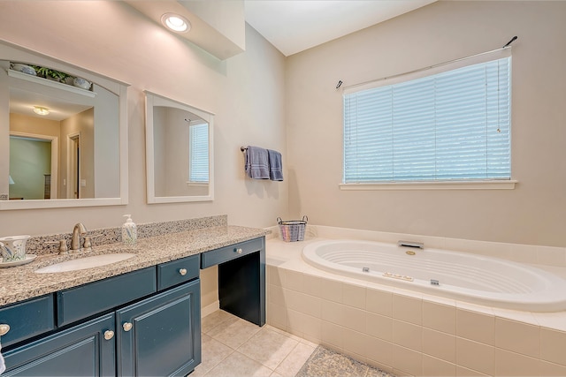 bathroom featuring tile patterned flooring, a bath, vanity, and healthy amount of natural light