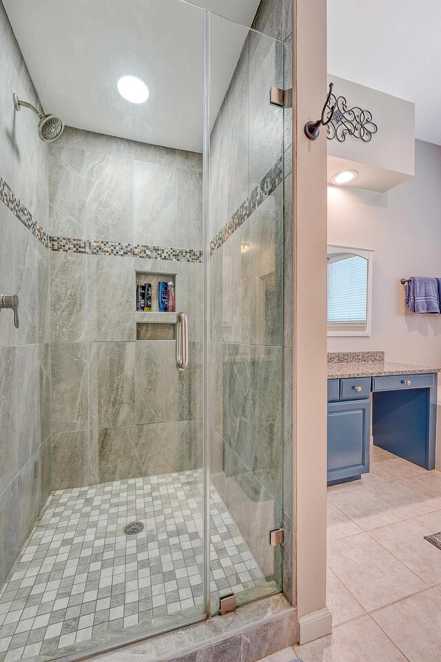full bath with a stall shower, tile patterned flooring, and vanity