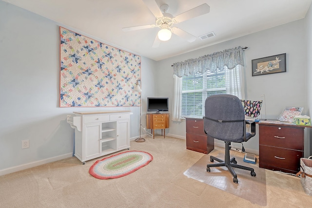 home office featuring light colored carpet, a ceiling fan, and baseboards