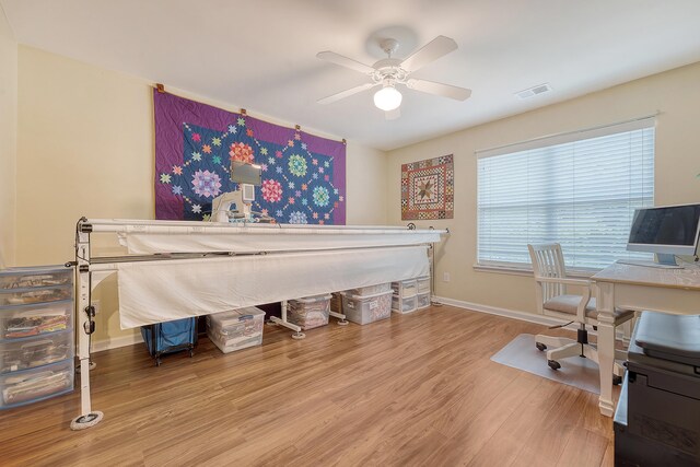 bedroom with wood finished floors, baseboards, ceiling fan, and a desk