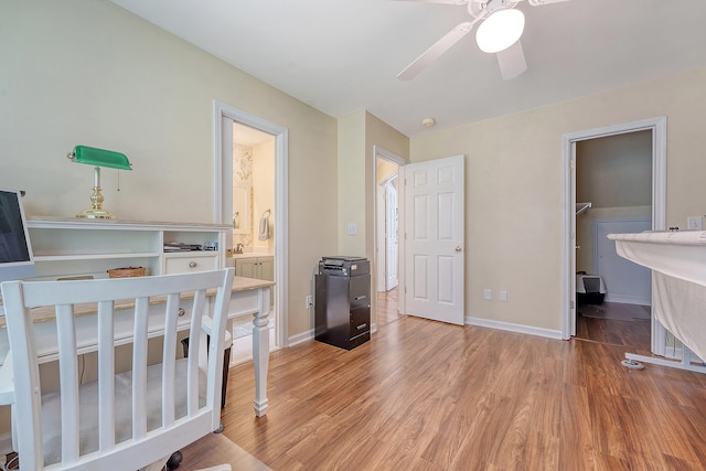 bedroom with light wood-type flooring, baseboards, and a walk in closet