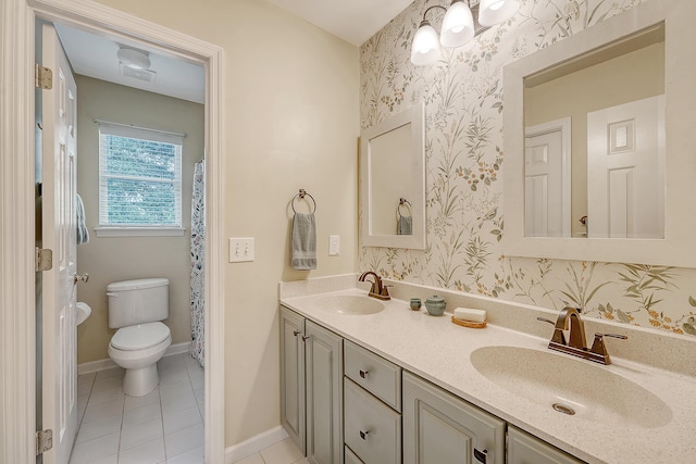 bathroom with toilet, wallpapered walls, double vanity, tile patterned floors, and baseboards