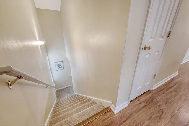 stairway featuring wood finished floors and baseboards