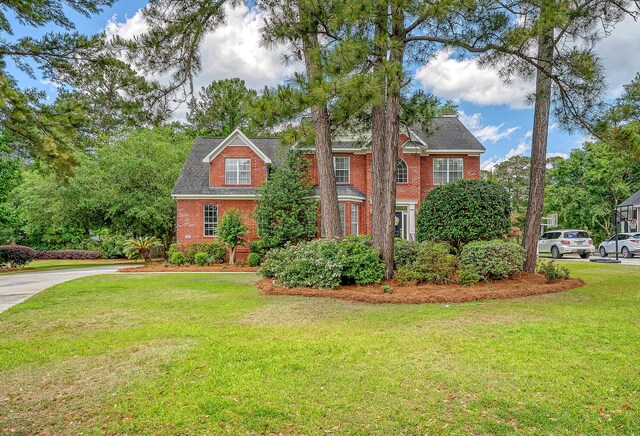 view of front of house featuring brick siding and a front yard