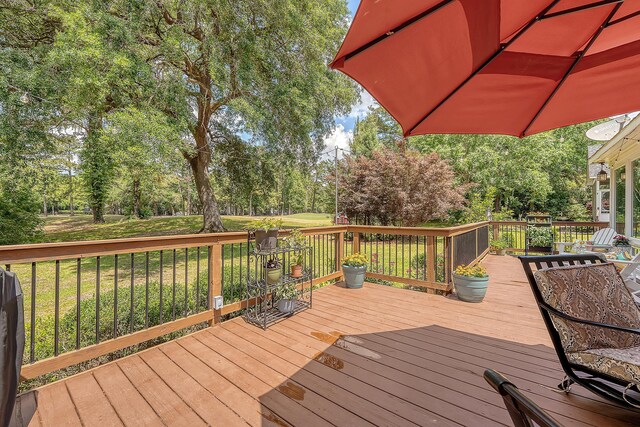 wooden terrace featuring view of scattered trees and a yard