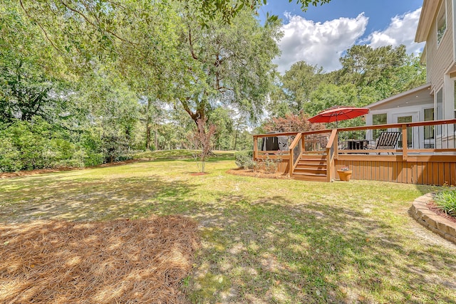 view of green lawn featuring a deck