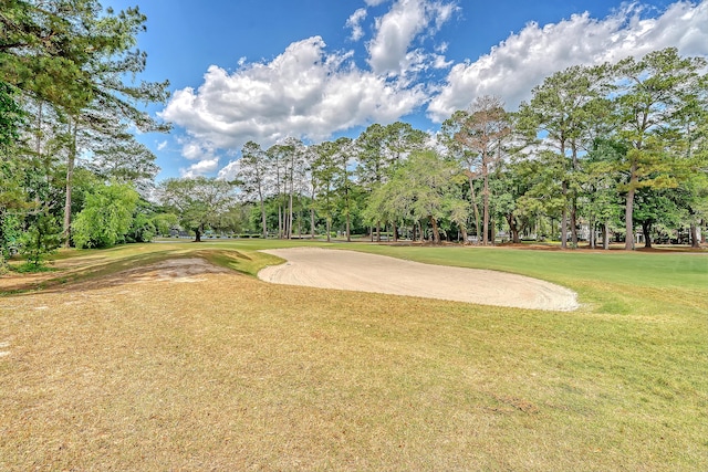 surrounding community with view of scattered trees, a lawn, and view of golf course