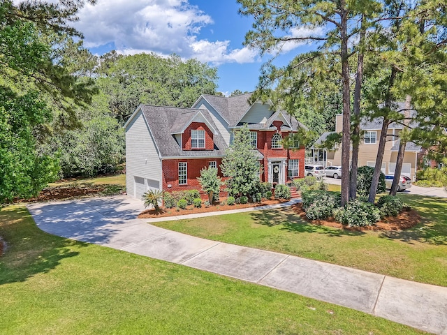 view of front of home with brick siding, driveway, an attached garage, and a front lawn