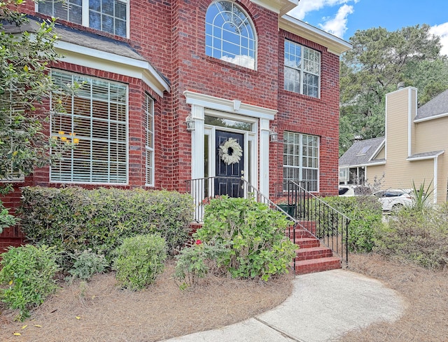 view of exterior entry featuring brick siding