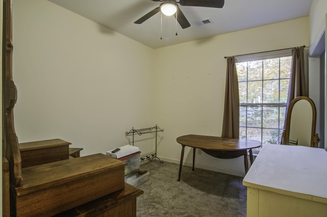 carpeted home office featuring ceiling fan