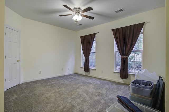 carpeted empty room featuring ceiling fan and a healthy amount of sunlight