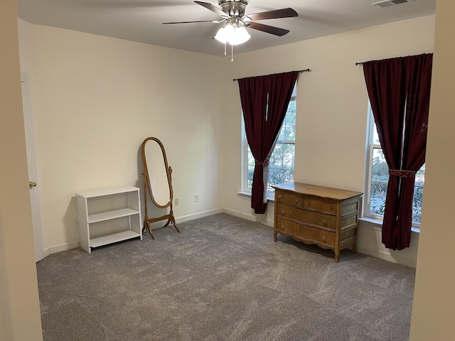 interior space with ceiling fan and dark carpet