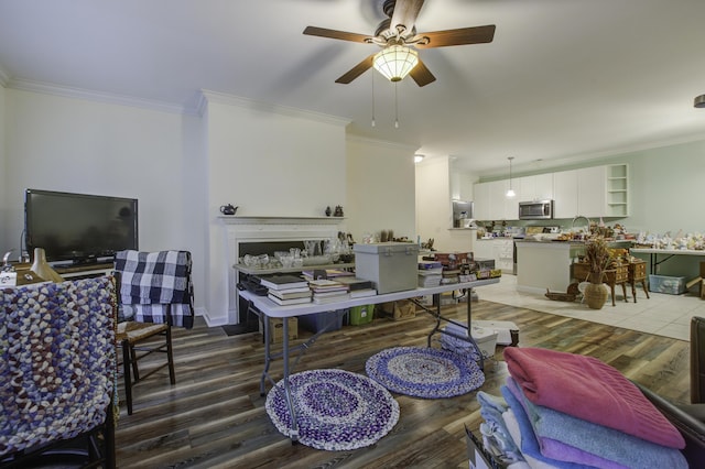 living room with ceiling fan, ornamental molding, and hardwood / wood-style floors