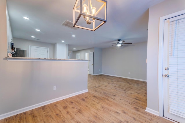 empty room with ceiling fan, baseboards, and wood finished floors