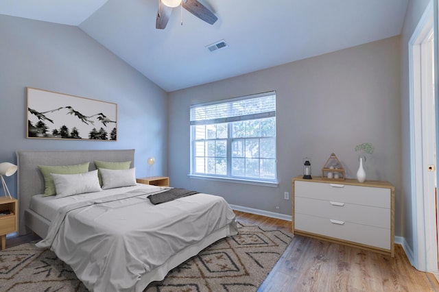 bedroom featuring visible vents, a ceiling fan, vaulted ceiling, light wood-type flooring, and baseboards