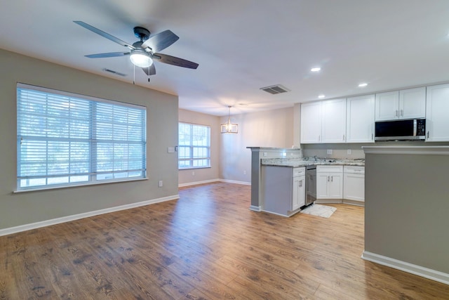 kitchen with white cabinets, stainless steel appliances, visible vents, and light wood-style floors