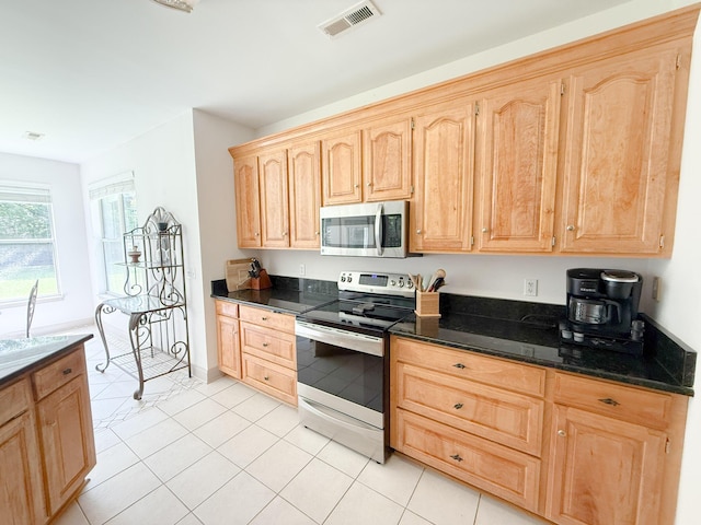1804 Bass Rd, Moncks Corner, SC 29461 - kitchen with stainless steel appliances, light brown cabinetry, dark stone counters, and light tile patterned flooring