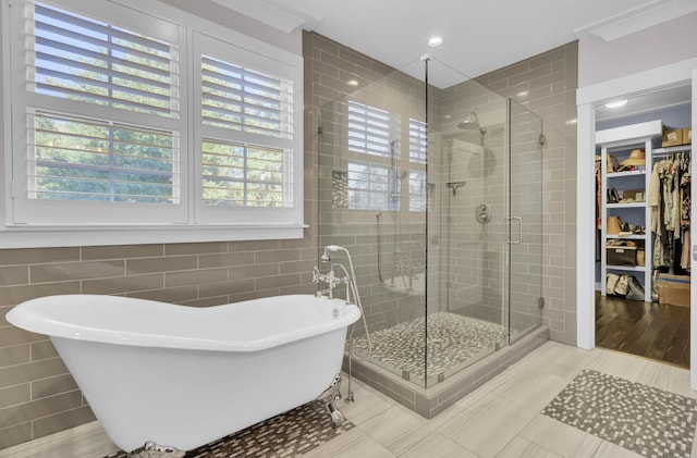 828 Bridge Point Cir, Mount Pleasant, SC 29464 - bathroom featuring tile walls, a freestanding bath, a stall shower, plenty of natural light, and a spacious closet