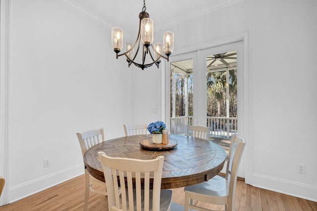 dining space featuring light hardwood / wood-style flooring, a chandelier, and ornamental molding