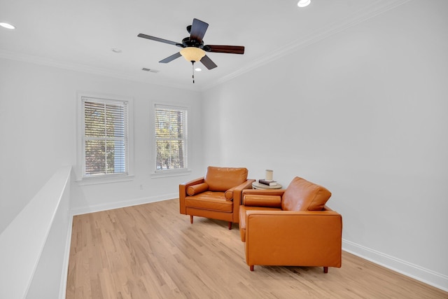 living area featuring light hardwood / wood-style floors, ornamental molding, and ceiling fan