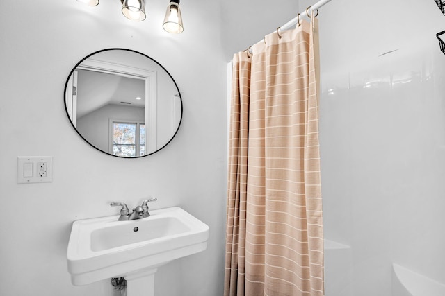 bathroom featuring vaulted ceiling and sink