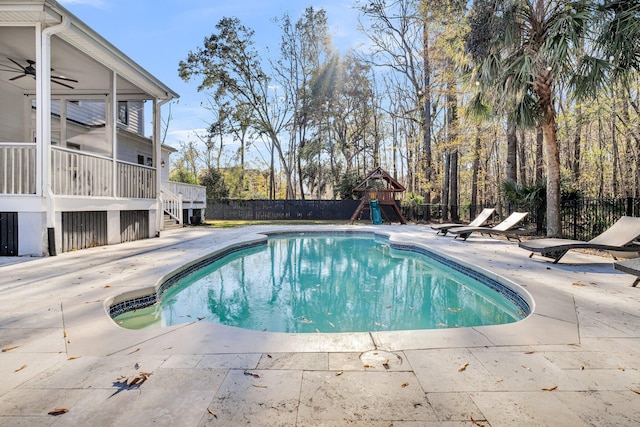 view of swimming pool with ceiling fan, a patio area, and a playground