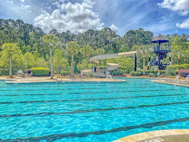 view of swimming pool with a playground and a patio area