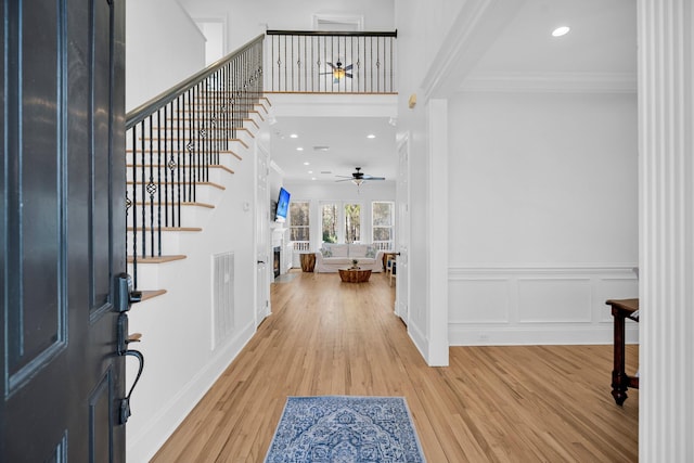 entryway with ceiling fan, ornamental molding, and hardwood / wood-style floors