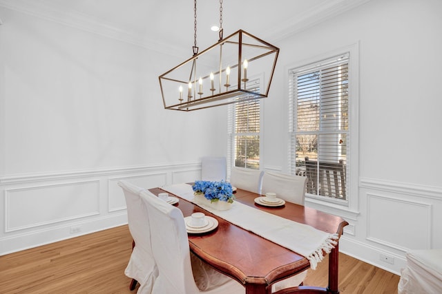 dining room with crown molding, an inviting chandelier, and hardwood / wood-style flooring