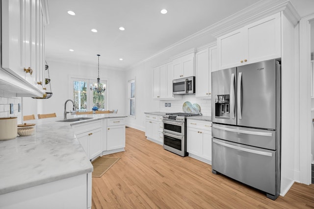 kitchen with stainless steel appliances, pendant lighting, white cabinets, and sink