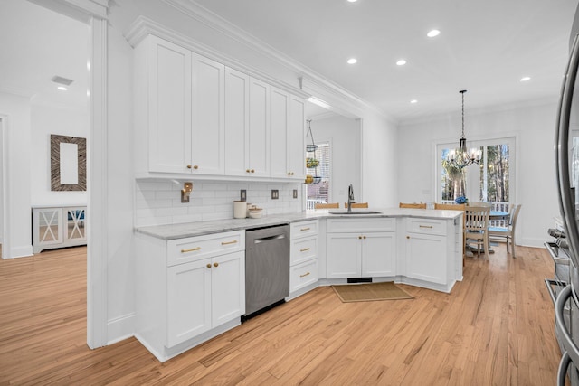 kitchen featuring decorative light fixtures, white cabinets, dishwasher, and sink